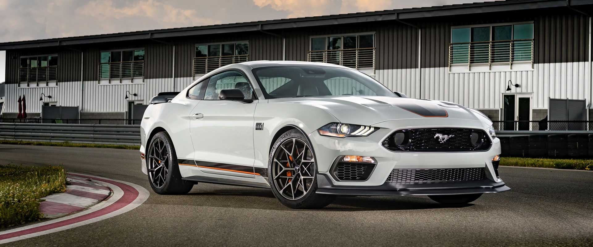 White car parked on road front of building